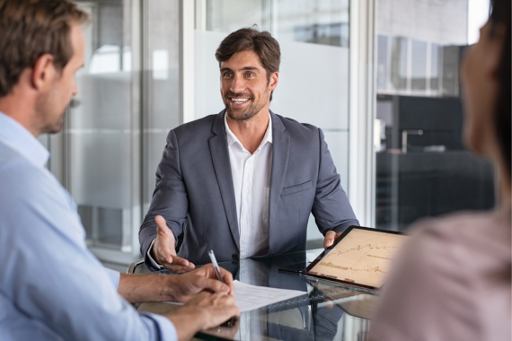  man in a suit talking to a colleague in a meeting room